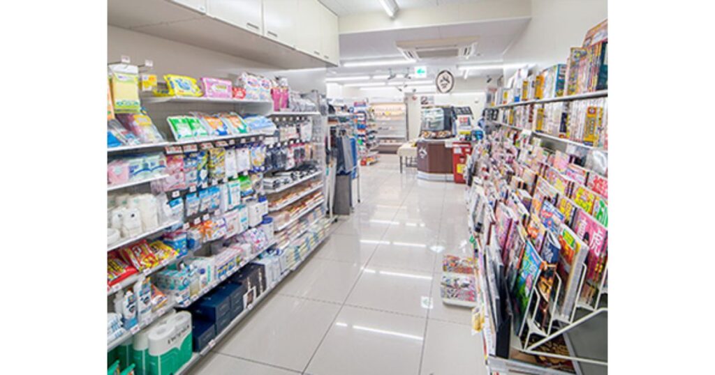 雑誌や日用品、雑貨などがきれいに陳列されたコンビニエンスストアの病院店内通路