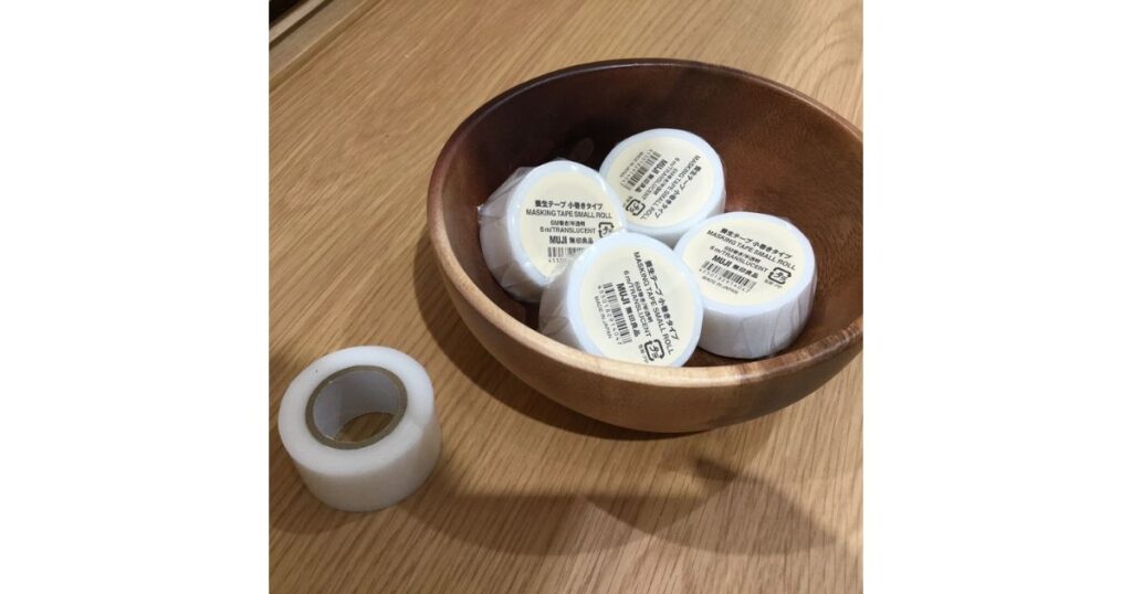 木製のボウルに入れられた無印良品の「養生テープ 小巻きタイプ(半透明)」と、開封されたテープの写真