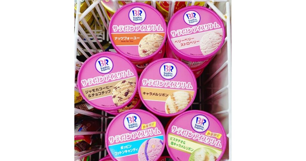 冷凍庫のワイヤーバスケットに入った、サーティワンアイスクリームのカップの詰め合わせ。それぞれのカップのフタには、BRのロゴと、ナッツフォーユー、ベリーベリーストロベリーなどの日本語フレーバー名とアイスの画像が書かれている。