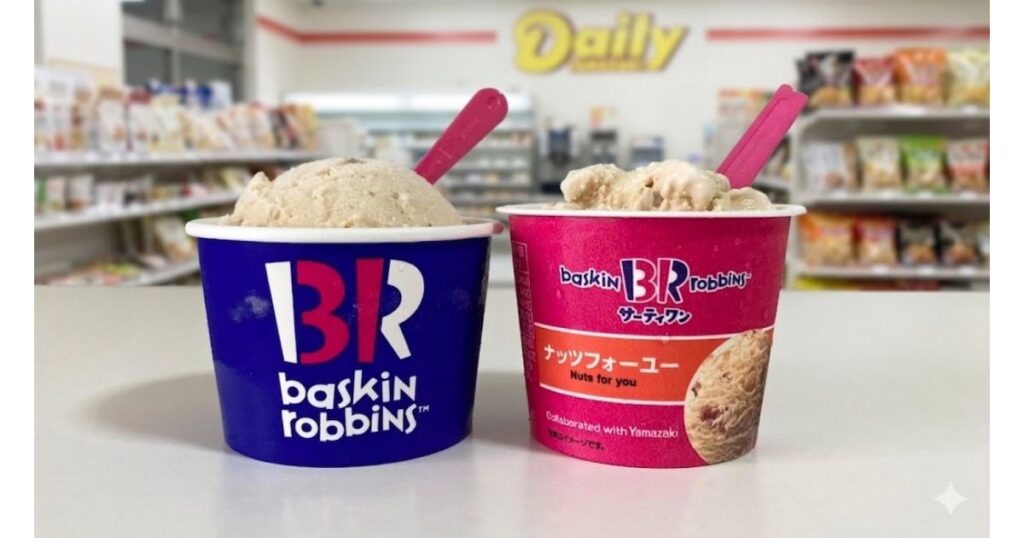 白いカウンターの上に置かれた、サーティワンアイスクリームのカップ2個。左側は青いカップでBRのロゴ。右側はピンク色のカップで「ナッツフォーユー」と書かれている。それぞれのカップにピンク色のスプーンが刺さっている。背景は、ボケたデイリーヤマザキの店内。