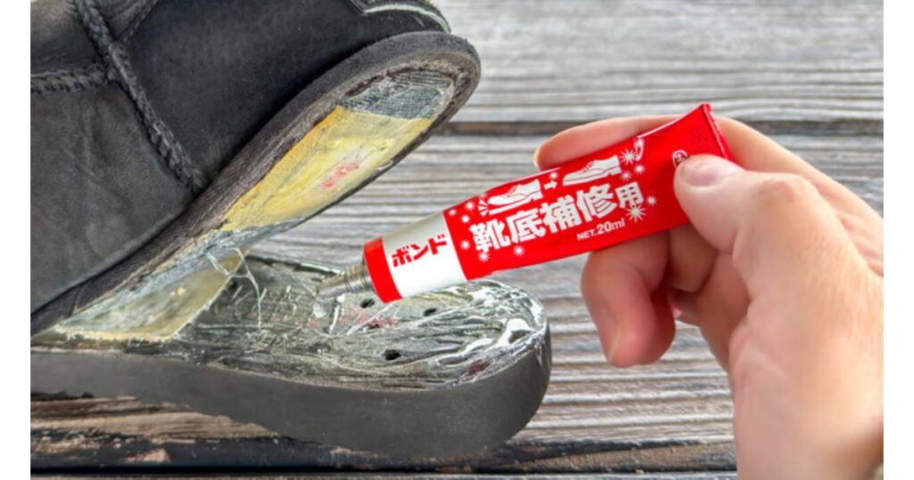 外出先で剥がれてしまった靴底に、専用の靴底補修用ボンドを塗って応急処置をしている様子
