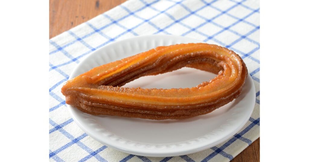 青いチェックのランチョンマットと白いお皿に乗せられたローソンの「牛乳仕込みのザクっとチュロッキー」