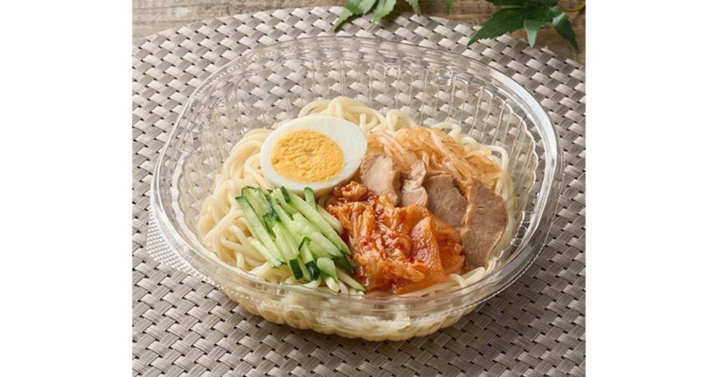透明なプラスチック容器に入った、ゆで卵、キムチ、きゅうり、チャーシューが盛り付けられた正統派のコンビニ盛岡風冷麺。