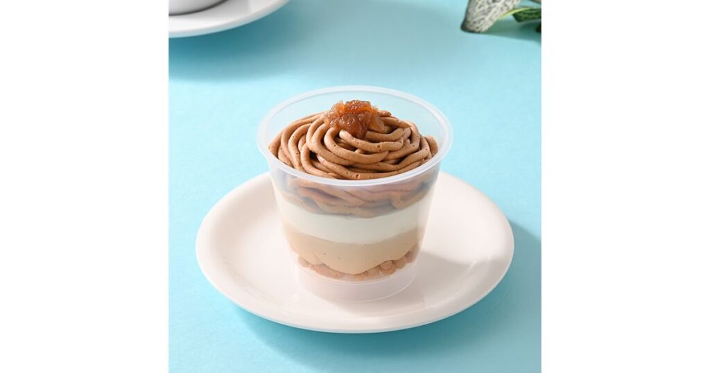 透明なカップに入った層状のモンブランスイーツ。上に絞られたマロンクリームの下に、白いホイップやムースの層が重なっている。