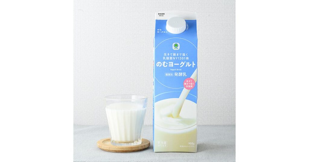 ファミリーマートの『のむヨーグルト 900g』紙パックと、グラスに注がれた飲むヨーグルト。背景に乳酸菌NY1301株の記載