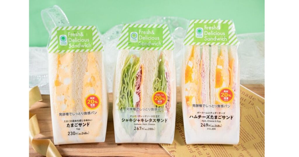 具材20%増量キャンペーンのシールが貼られたファミリーマートのたまごサンドなど3種類のサンドイッチ
