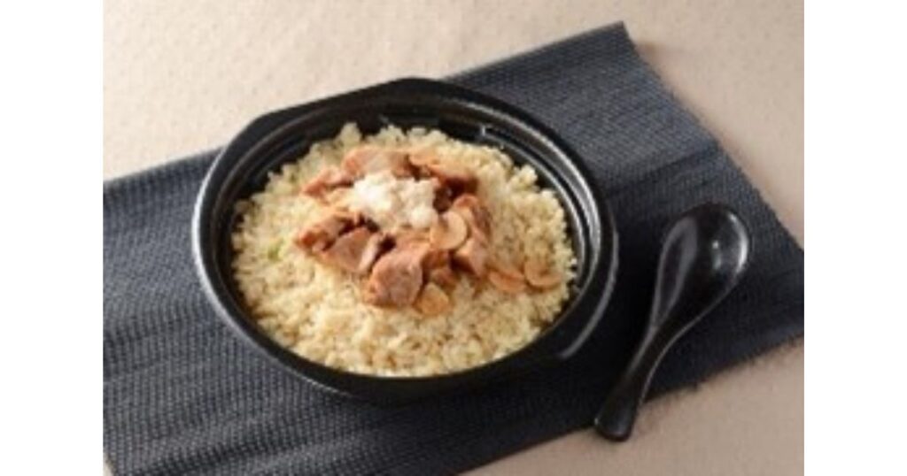 黒い器に盛られた、大きめのお肉や背脂がトッピングされたボリュームのあるガッツリ系チャーハン