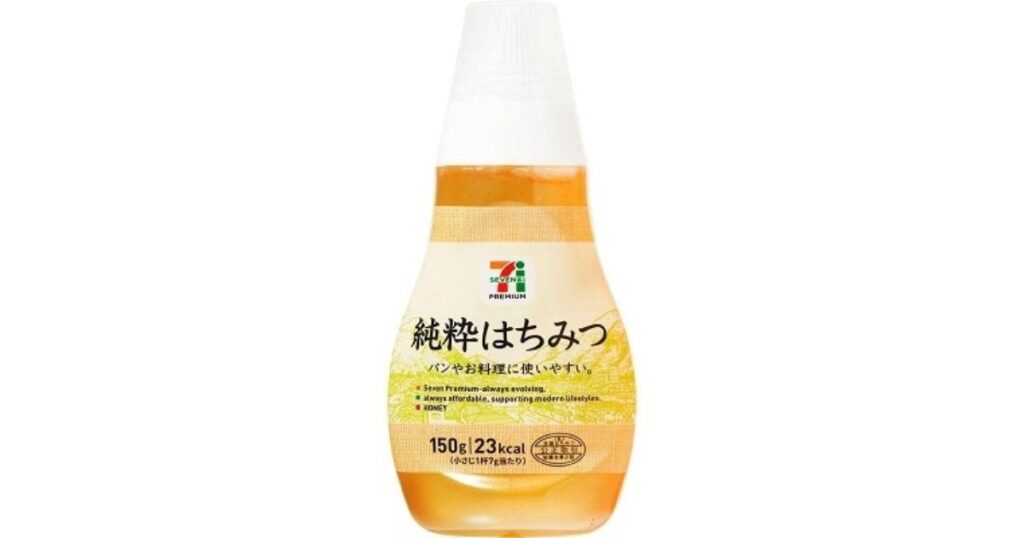 白い背景に置かれた、セブンプレミアムの「純粋はちみつ」のスクイズボトル（150g）。ラベルにはセブン＆アイのロゴ、商品名、カロリー、注意事項が記載されている。