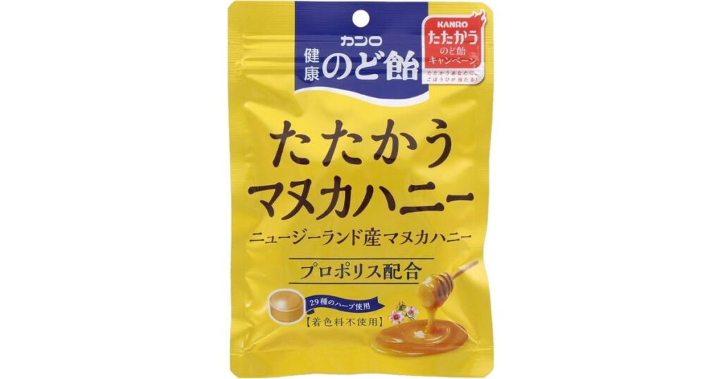 黄色いパッケージに入った、カンロの「健康のど飴 たたかうマヌカハニー」。パッケージには、「ニュージーランド産マヌカハニー」「プロポリス配合」「29種のハーブ使用」といった特徴と、飴とはちみつのイラストが描かれている。