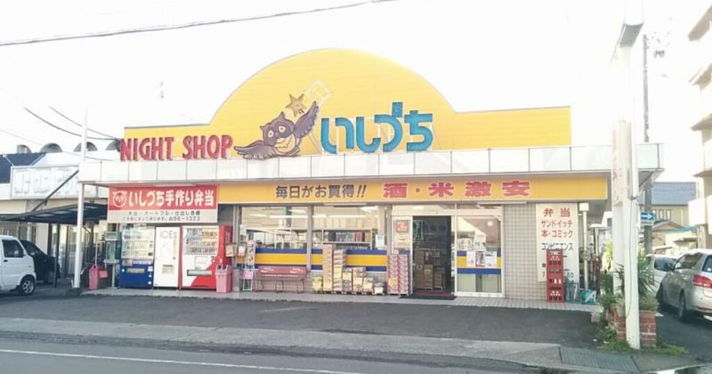 黄色い半円形の看板にフクロウのロゴと「NIGHT SHOP いしづち」の文字が掲げられたコンビニエンスストアの外観