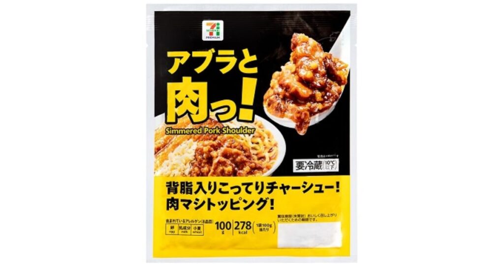 セブンプレミアムのトッピング商品「アブラと肉っ！ Simmered Pork Shoulder」のパッケージ。背脂入りこってりチャーシューで肉マシトッピングであることを説明するテキストと、レンゲに盛られた商品の写真が掲載されている。100g当たり278kcalの表示あり。