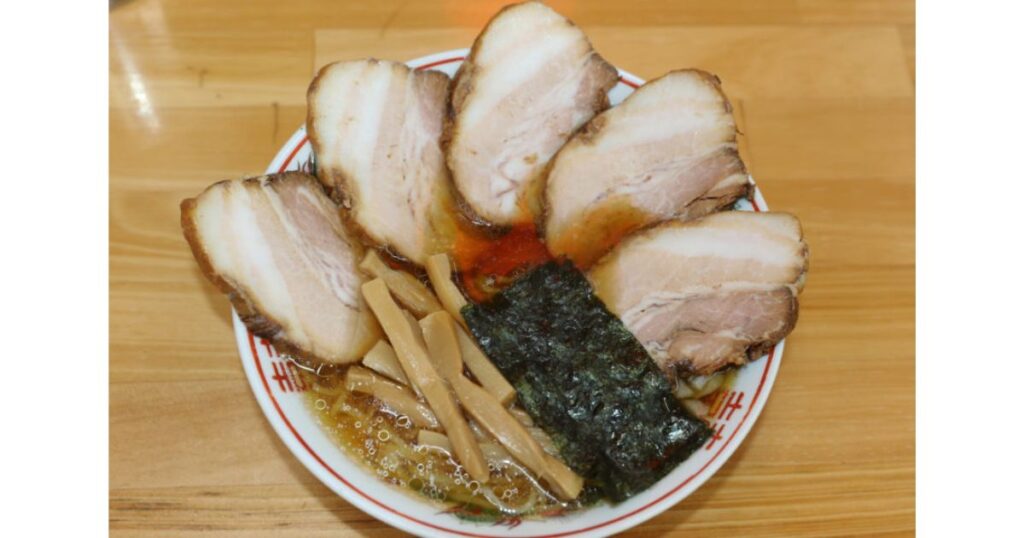 丼の表面を覆い尽くすほどの分厚い肉が乗った小西屋（醤家）のチャーシュー麺