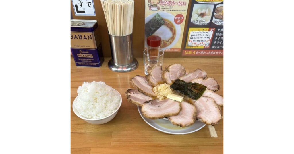 花びらのように盛り付けられたダブルチャーシュー麺とお茶碗山盛りの1合ライス