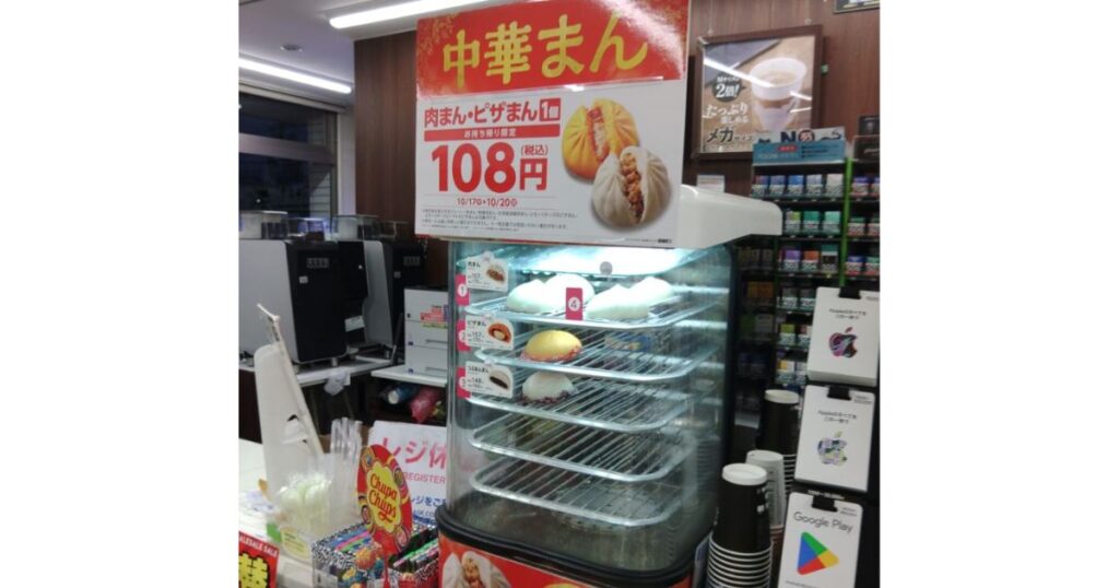 コンビニのレジ横に設置された中華まんの専用スチーマー（保温ケース）とセールのPOP看板