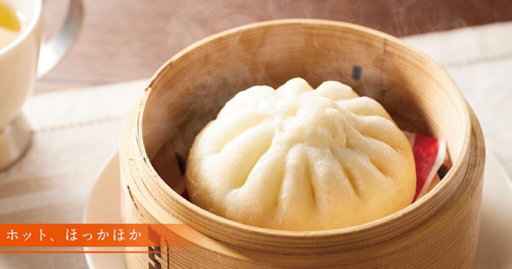 竹のせいろ（蒸し器）に入った、湯気を立てるほかほかで美味しそうな肉まん