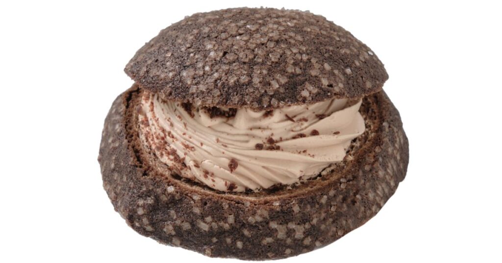 チョコホイップクリームがたっぷりサンドされた、表面に砂糖がまぶされた黒いチョコレートメロンパン"