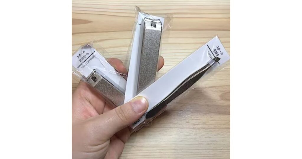 シンプルなデザインの、手に持たれた2種の爪切りと1種の毛抜き。