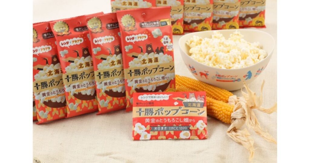 電子レンジ専用「十勝ポップコーン」の赤いパッケージと、お皿に盛られた出来立てのポップコーン、乾燥とうもろこし