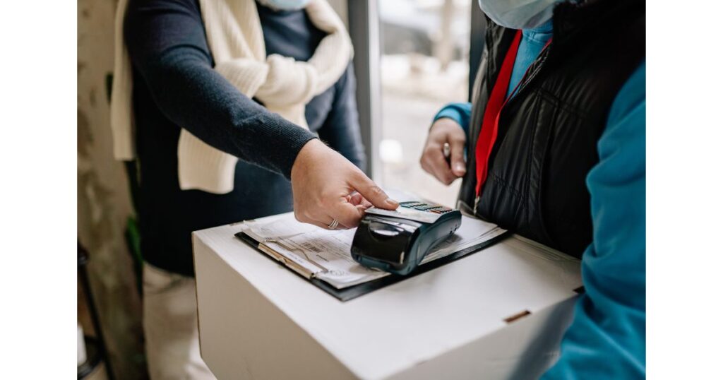 専用端末にクレジットカードをかざしてキャッシュレス決済をしている様子のイメージ画像