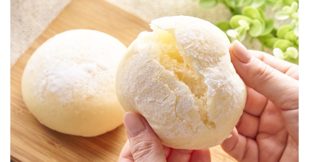 両手で半分に割られた、白くてもっちりとした柔らかい米粉パンの断面