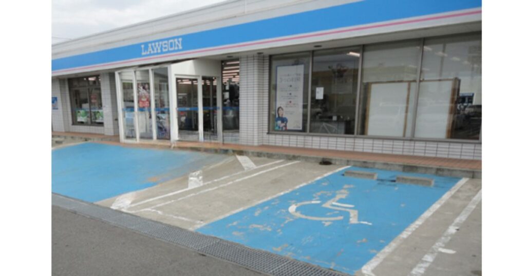 入り口の目の前に車椅子・ベビーカー優先の青い駐車スペースとスロープが整備されているローソンの店舗外観