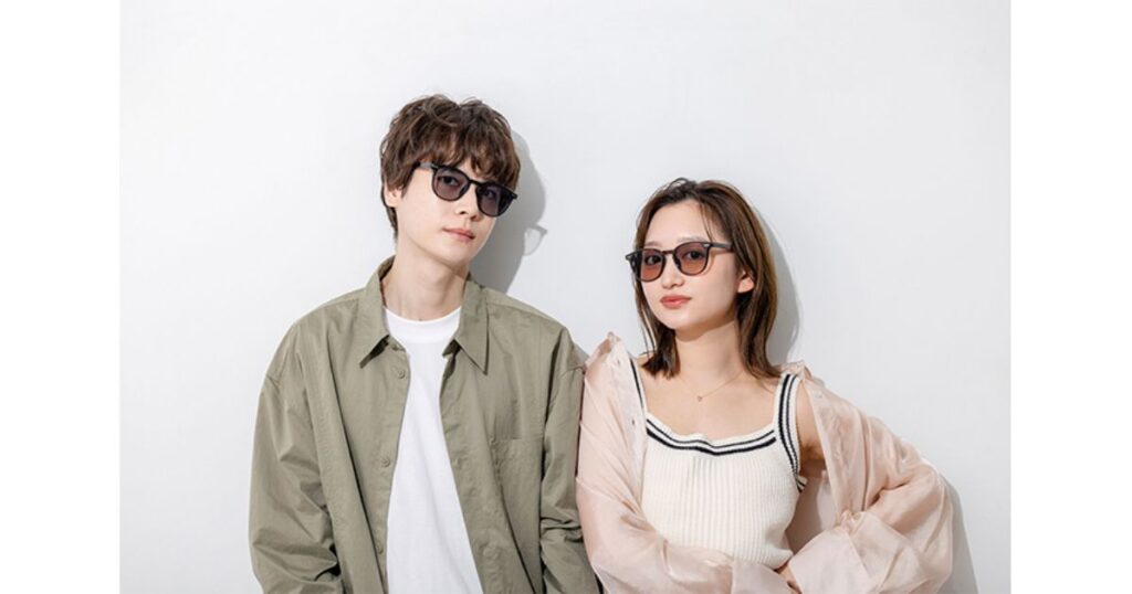 サングラスを着用してポーズをとる若い男女のモデル。カーキ色のシャツを着た男性は黒ぶちのサングラスを、ピンク系の服を着た女性はべっ甲柄のサングラスをかけている。
