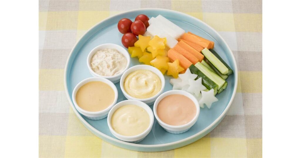 水色の丸いお皿に並べられた星型カットのパプリカや大根、きゅうりのスティック、ミニトマトと4種類のディップソース