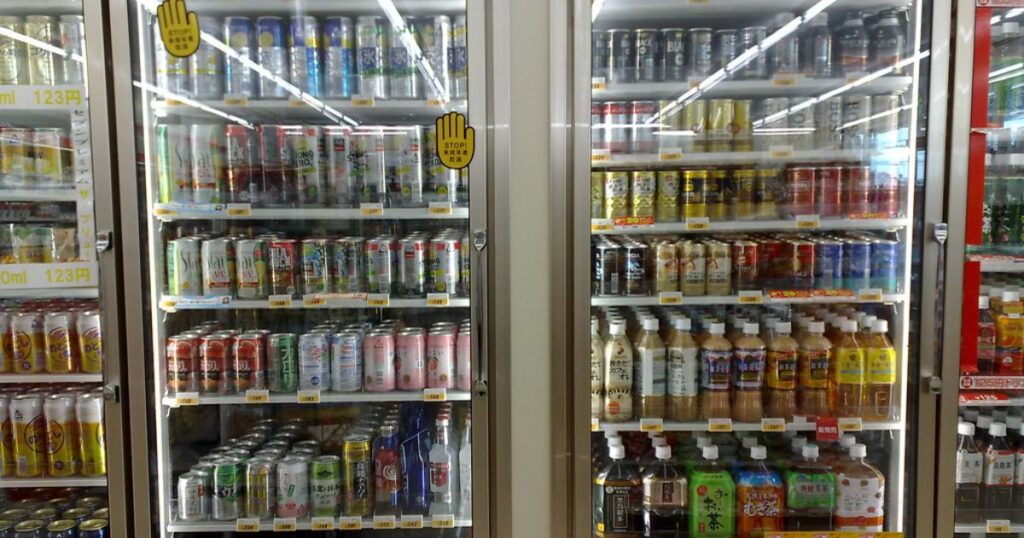 「コンビニエンスストアの冷蔵ケースに、アルコール飲料やお茶などのペットボトル飲料が整然と陳列されている様子。」