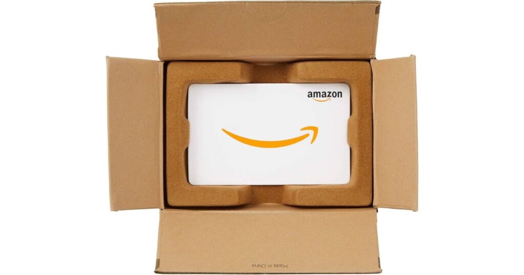 Amazonの配送用段ボール箱に収められた、白いAmazonギフトカード。コンビニ払い後の返金先や、チャージ決済をイメージする画像。