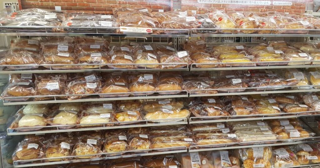 セブン-イレブンの店舗の棚にぎっしりと陳列された、種類豊富な袋入りパン