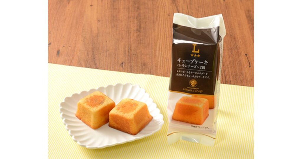 ローソンのウチカフェ「キューブケーキ レモンチーズ」のパッケージと、白いお皿に載った2つの四角いレモンチーズケーキ。