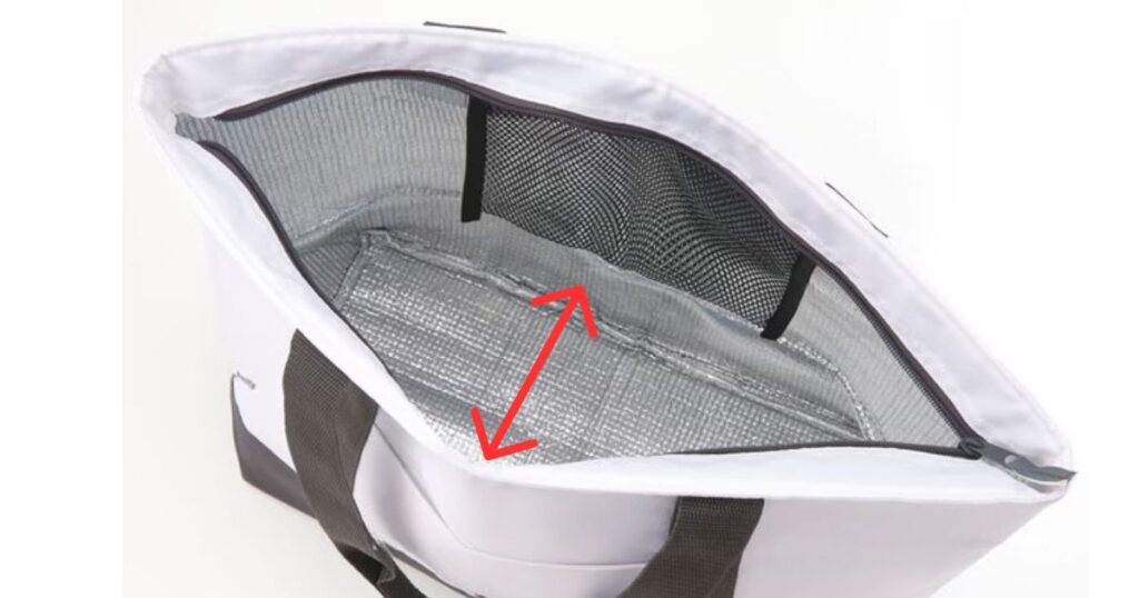 白い保冷バッグを上から見下ろした内部。銀色の断熱材（アルミ蒸着フィルム）が貼られており、マチの広さを赤い矢印で強調している。