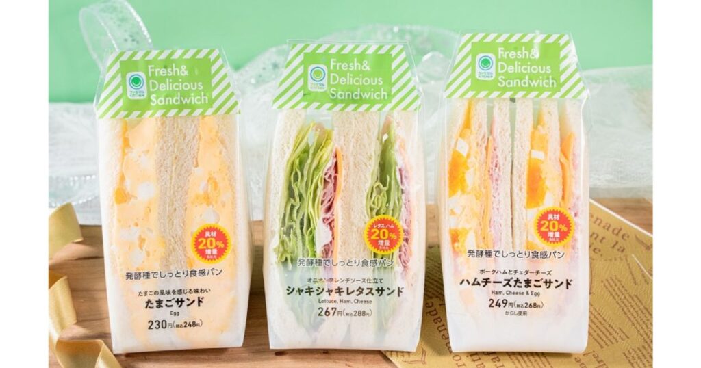 ファミリーマートの「具材20%増量」ラベルが貼られたたまごサンドやシャキシャキレタスサンドのパッケージ。