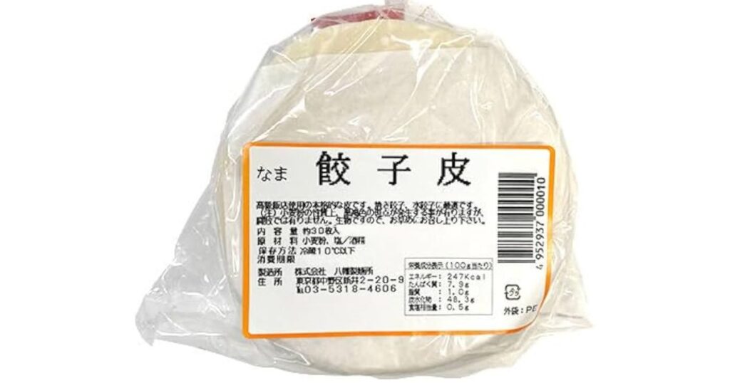 「八精製麺所」のラベルが貼られたシンプルな餃子の皮（約30枚入り、なま）。原材料名や保存方法が記載されている。