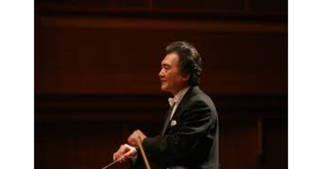 オーケストラの舞台で指揮棒を振る作曲家・指揮者の稲田康氏の横顔