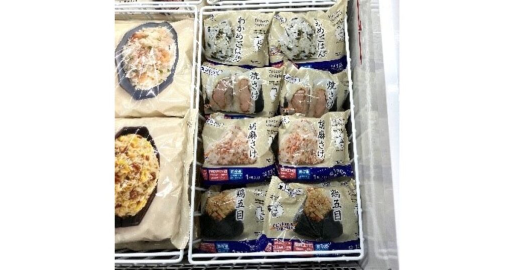 コンビニの店頭冷凍ケースに並ぶ、焼きさけや五目ごはんなど多種多様なフレーバーの冷凍おにぎり