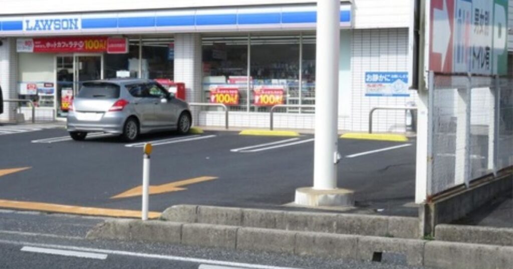 ローソン店舗の外観と手前に車が停まっている駐車場の風景