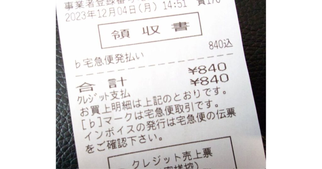 宅急便の元払いレシートの接写写真。金額840円の表示とともに、「インボイスの発行は宅急便の伝票をご確認下さい」という注意書きが印字されている様子。