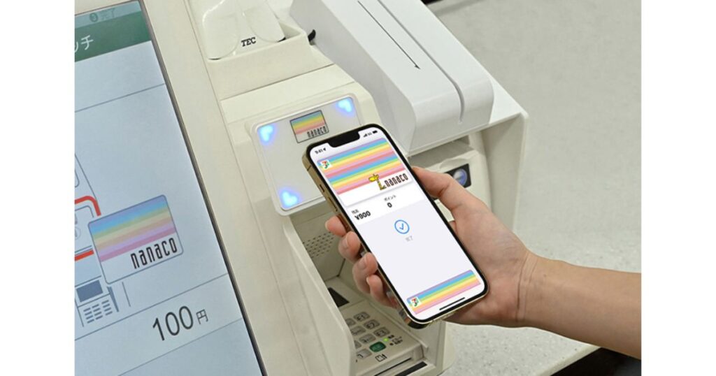 コンビニのレジ端末にスマートフォンをかざして電子マネーnanacoで支払う様子