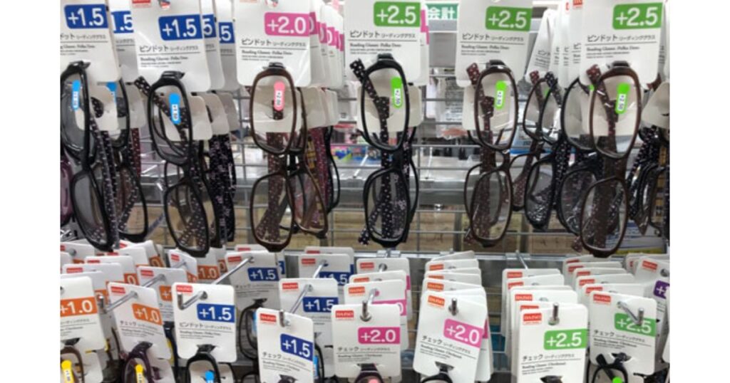 100円ショップの売り場に陳列された、さまざまな度数とデザインのピンドット柄リーディンググラス