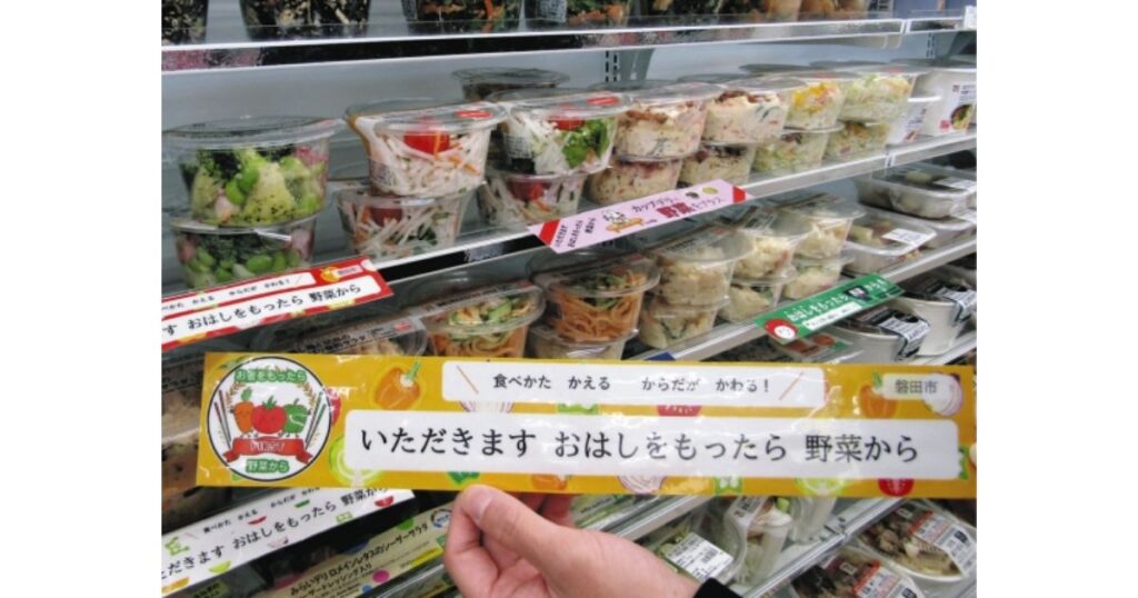 コンビニのサラダ売り場に掲示された「いただきます おはしをもったら 野菜から」というベジファーストを推奨するキャンペーンのPOP
