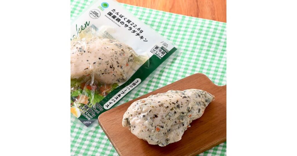 カッティングボードに乗せられた国産鶏使用のハーブ入りサラダチキンと、そのパッケージ写真