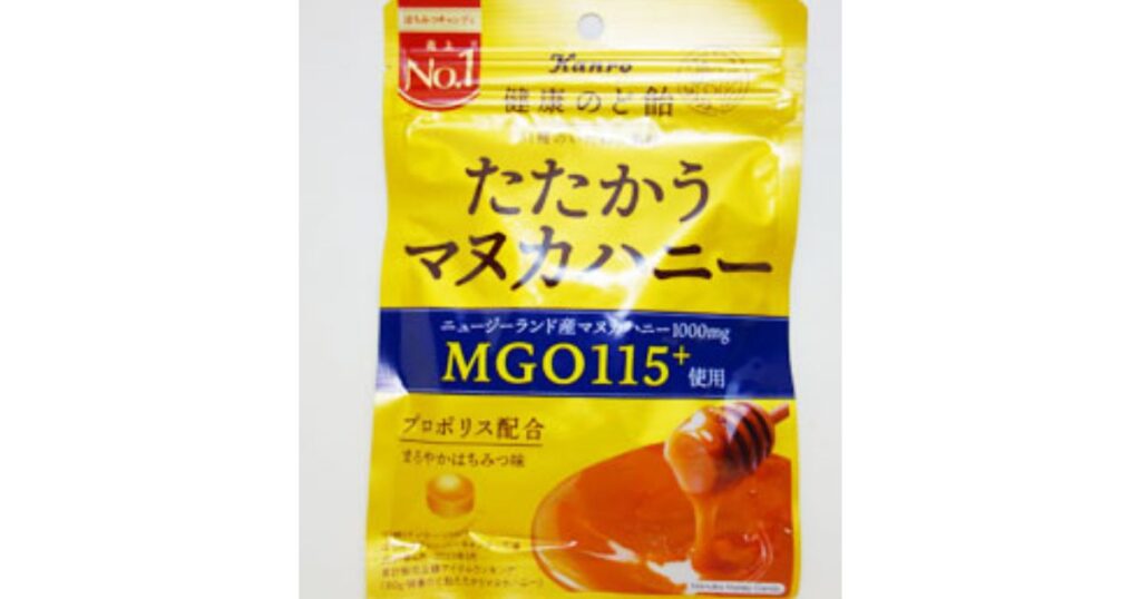 カンロ「健康のど飴 たたかうマヌカハニー」の黄色いパッケージ。中央に大きく「たたかうマヌカハニー」「MGO115+使用」の文字。