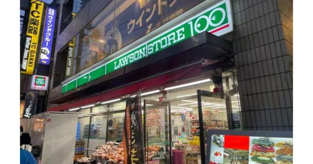 賑やかな街並みのビル1階に位置するローソンストア100の店舗外観