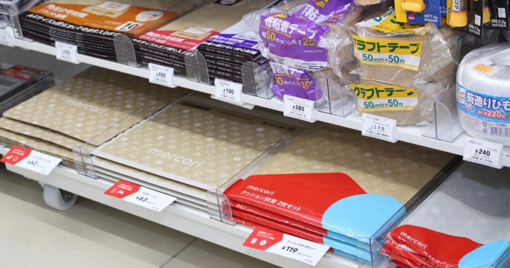 コンビニの棚に並ぶメルカリのクッション封筒やクラフトテープ、荷造りひもなどのフリマ・発送用梱包資材。