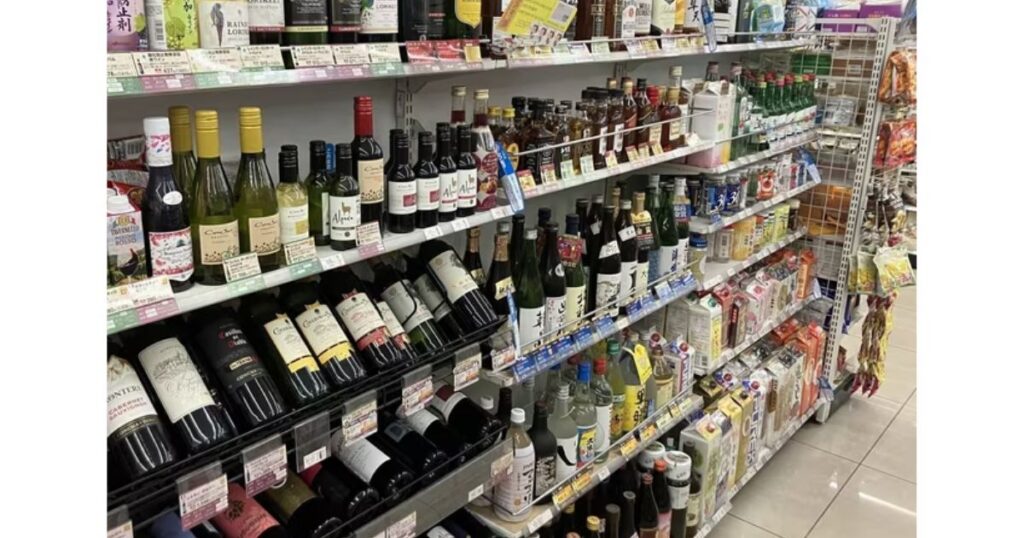 コンビニのお酒コーナーに並ぶ、ワインや日本酒などのアルコール飲料の棚。