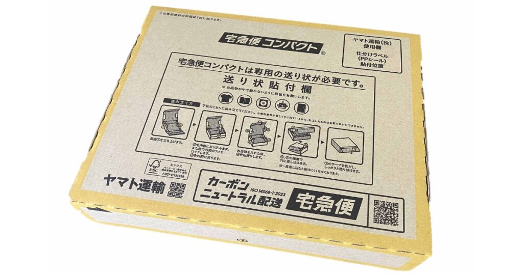 白背景の上に置かれた、組み立てられた状態のヤマト運輸「宅急便コンパクト」の専用薄型段ボール箱の実物写真。