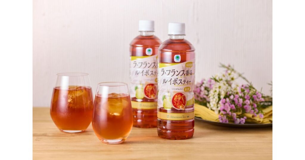 木目のテーブルに置かれたグラスと、ファミリーマートの「ラ・フランス香るルイボスティー」のペットボトル