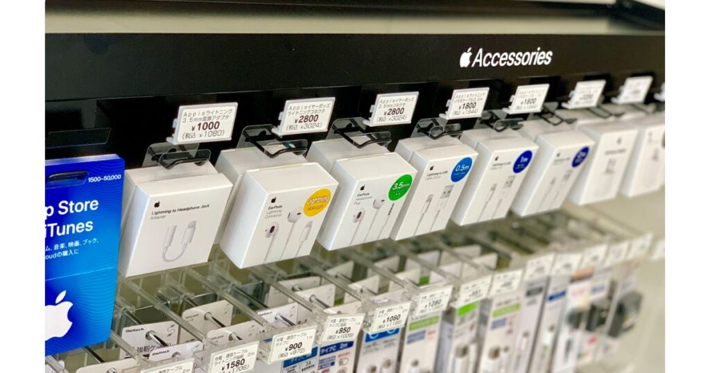 コンビニの棚に整然とフック陳列されているApple純正のLightningケーブルや有線イヤホンのパッケージ。